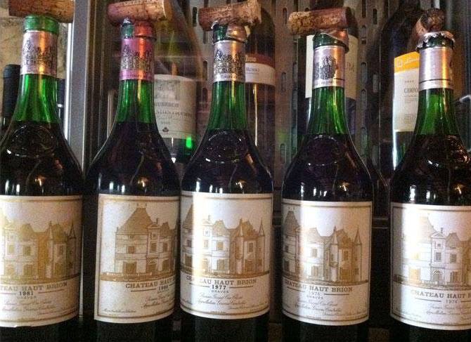 Diverse bottiglie di vino sono allineate in fila