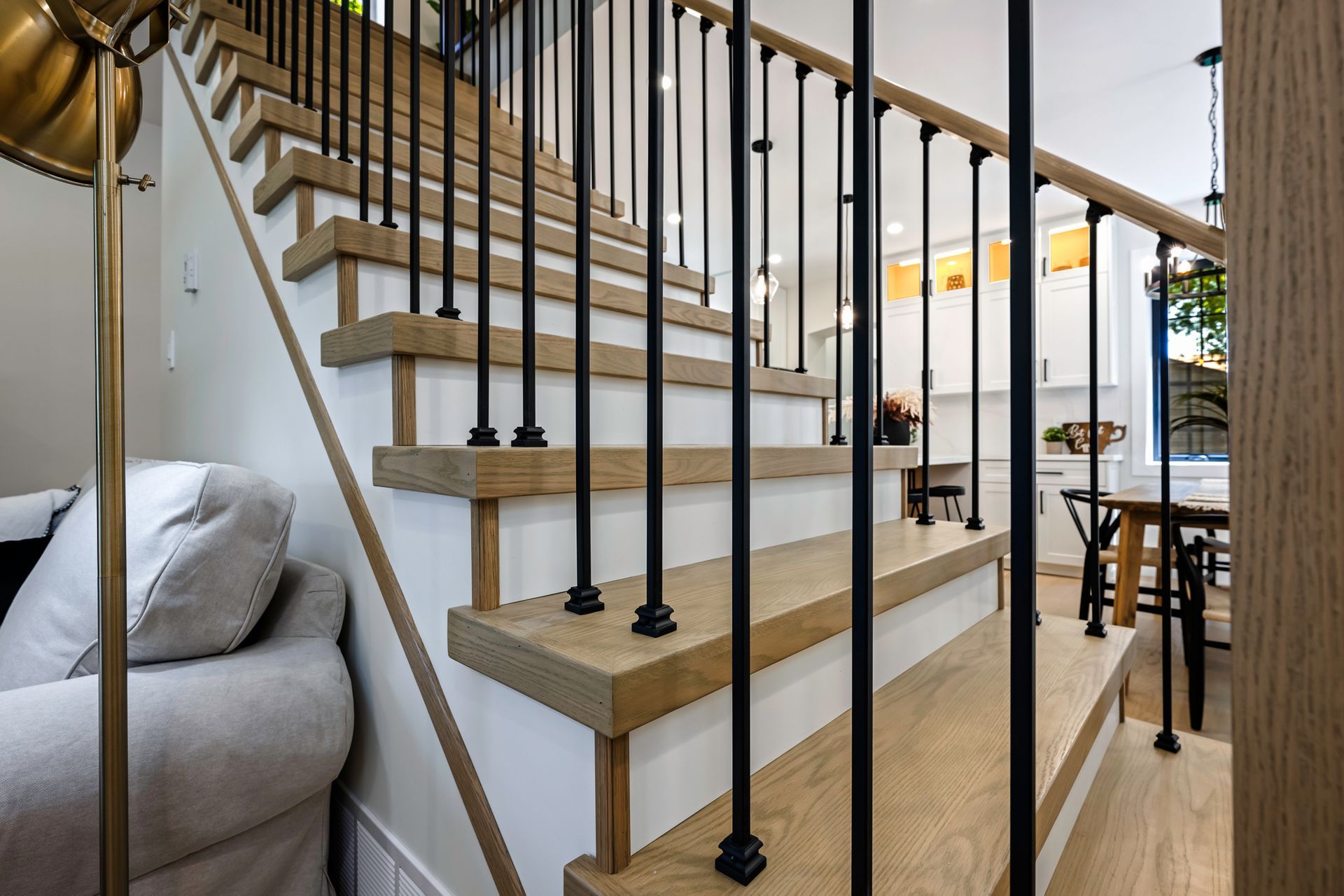 Wooden staircase with black railings and white risers in a home.