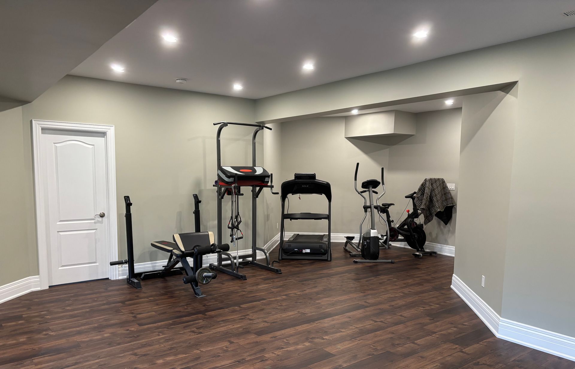Unfinished basement with exposed insulation, wood framing, and a concrete floor.