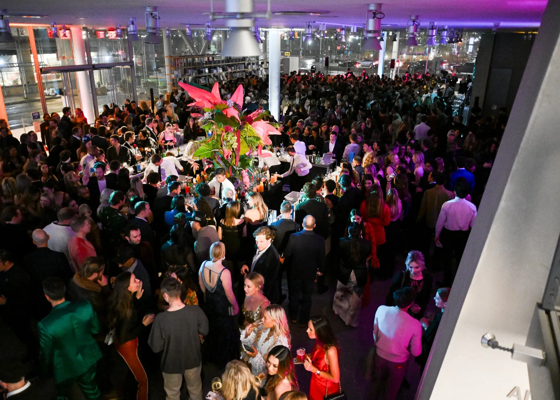 Large party in a brightly lit modern venue with many people mingling and celebrating.