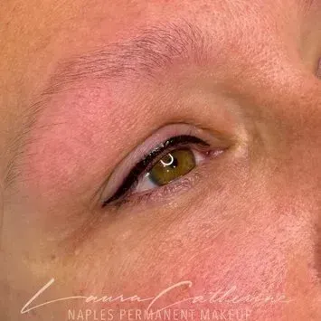 Close-up of a person's eye with permanent eyeliner in black, a light skin tone, and a hint of a brow.