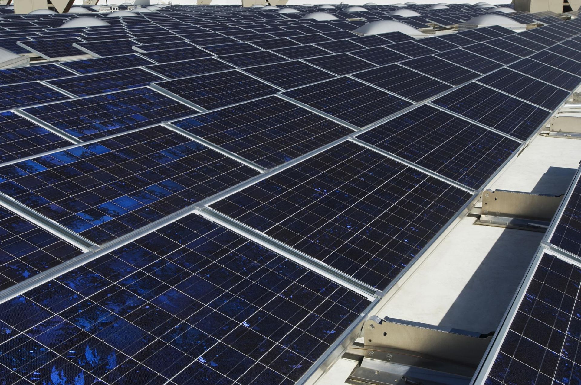A row of solar panels on a white roof