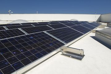 A row of solar panels on a white roof
