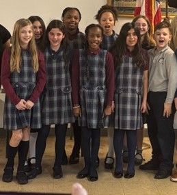 a boy and a girl are walking down a hallway holding hands