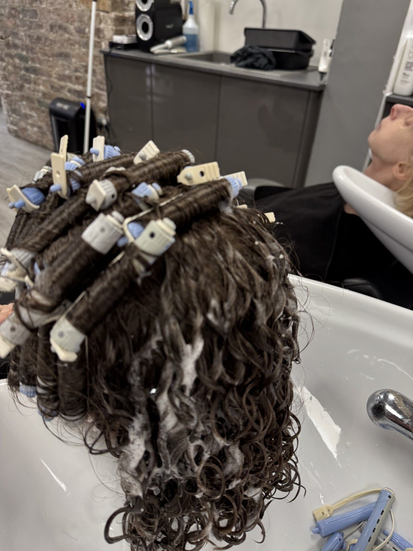 Perm rods being removed during a consultation-led curl transformation