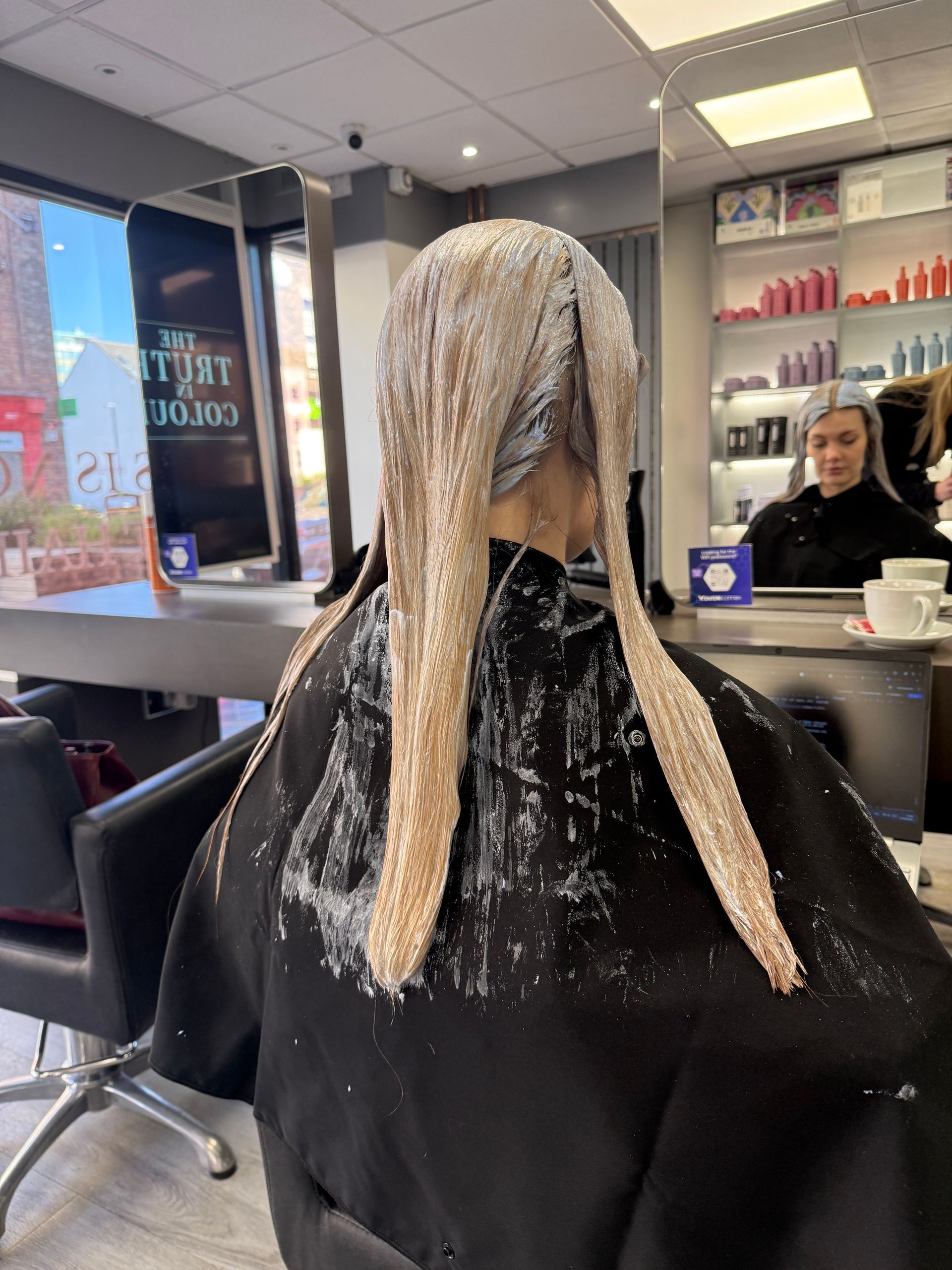 Hair colour correction process removing black box dye with controlled lightener application in salon
