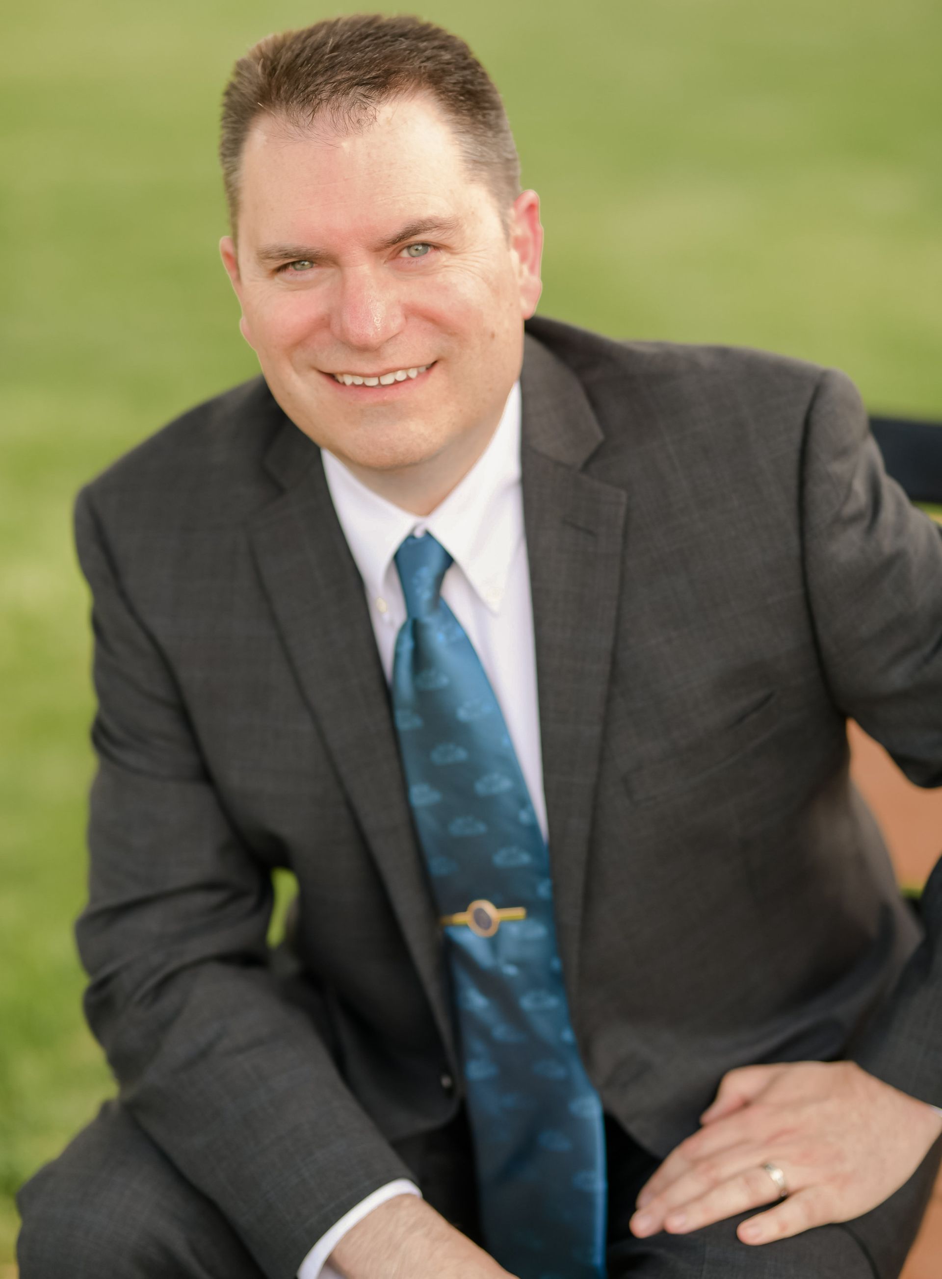 A man in a suit and tie is smiling for the camera