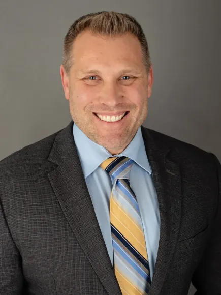 A man in a suit and tie is smiling for the camera.