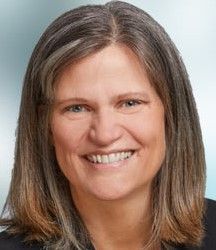 A woman with long hair is smiling for the camera.