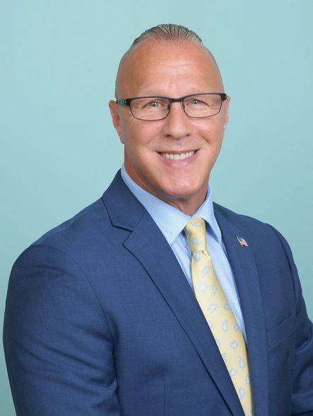 A man in a suit and tie is smiling for the camera.