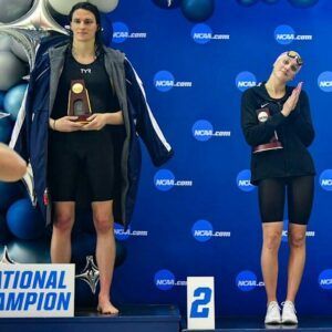 Two women standing on a podium with a sign that says national champion