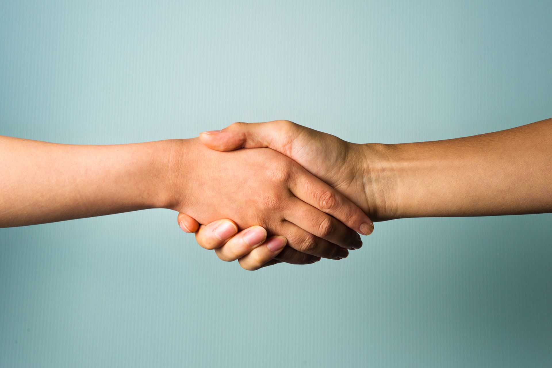 Two people are shaking hands on a blue background.