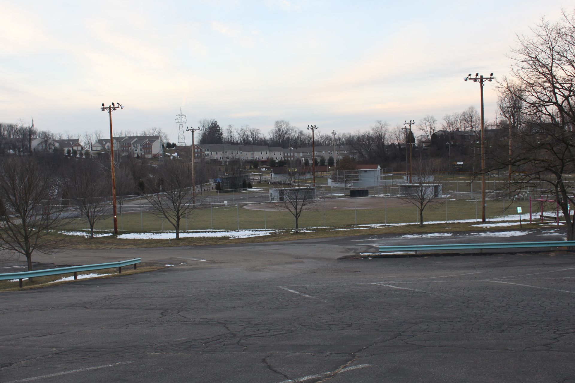 An empty parking lot with trees in the background