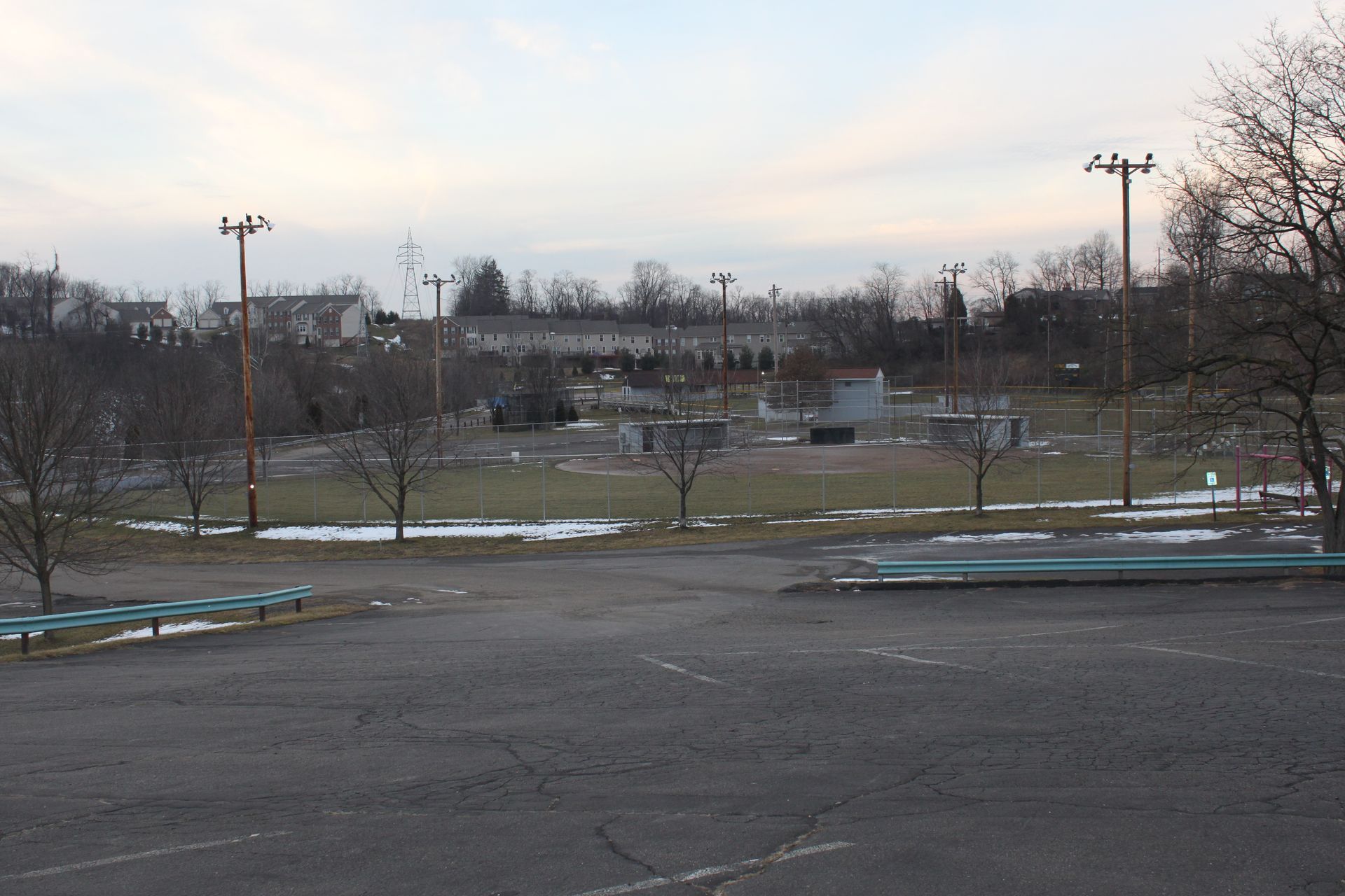 An empty parking lot with a field in the background