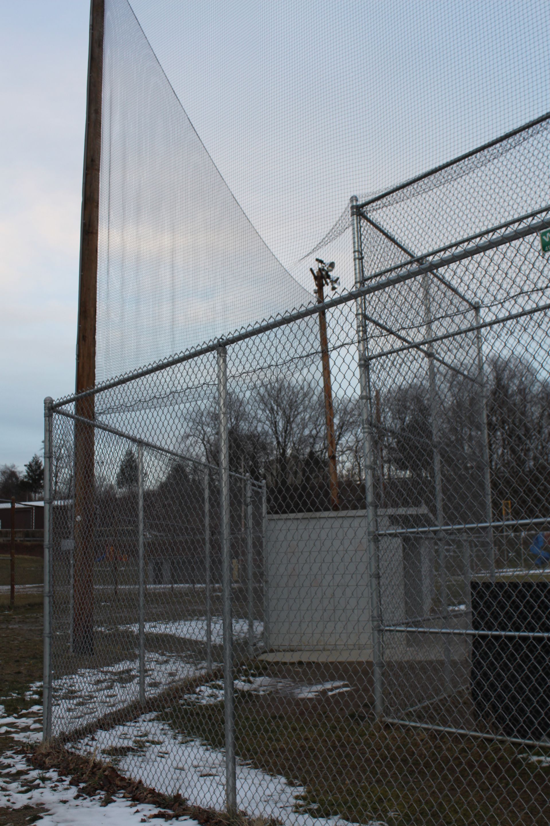 An empty parking lot with a field in the background