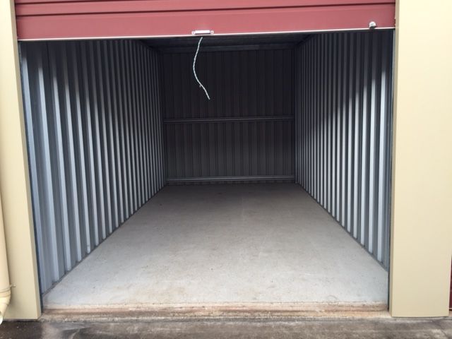 An empty storage shed with a red door