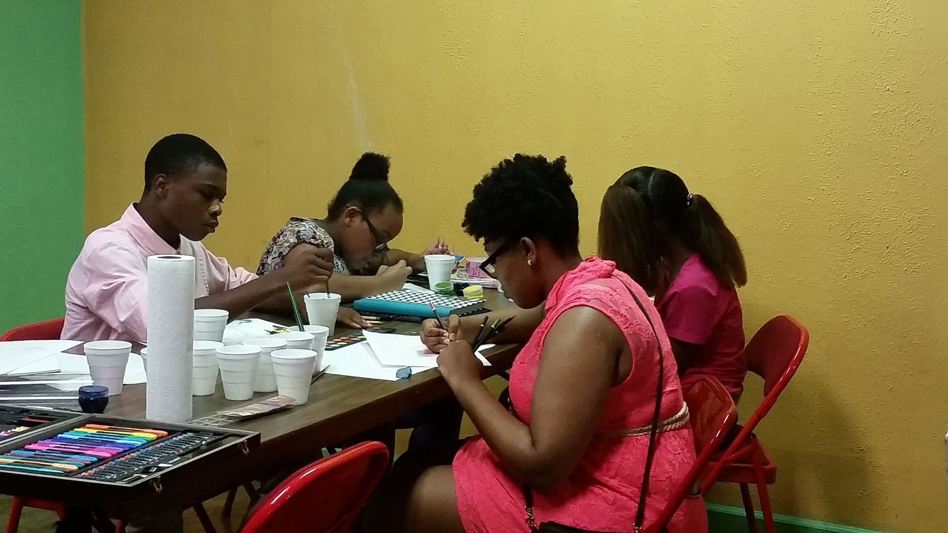 A Group of People Are Sitting Around a Table With Cups on It