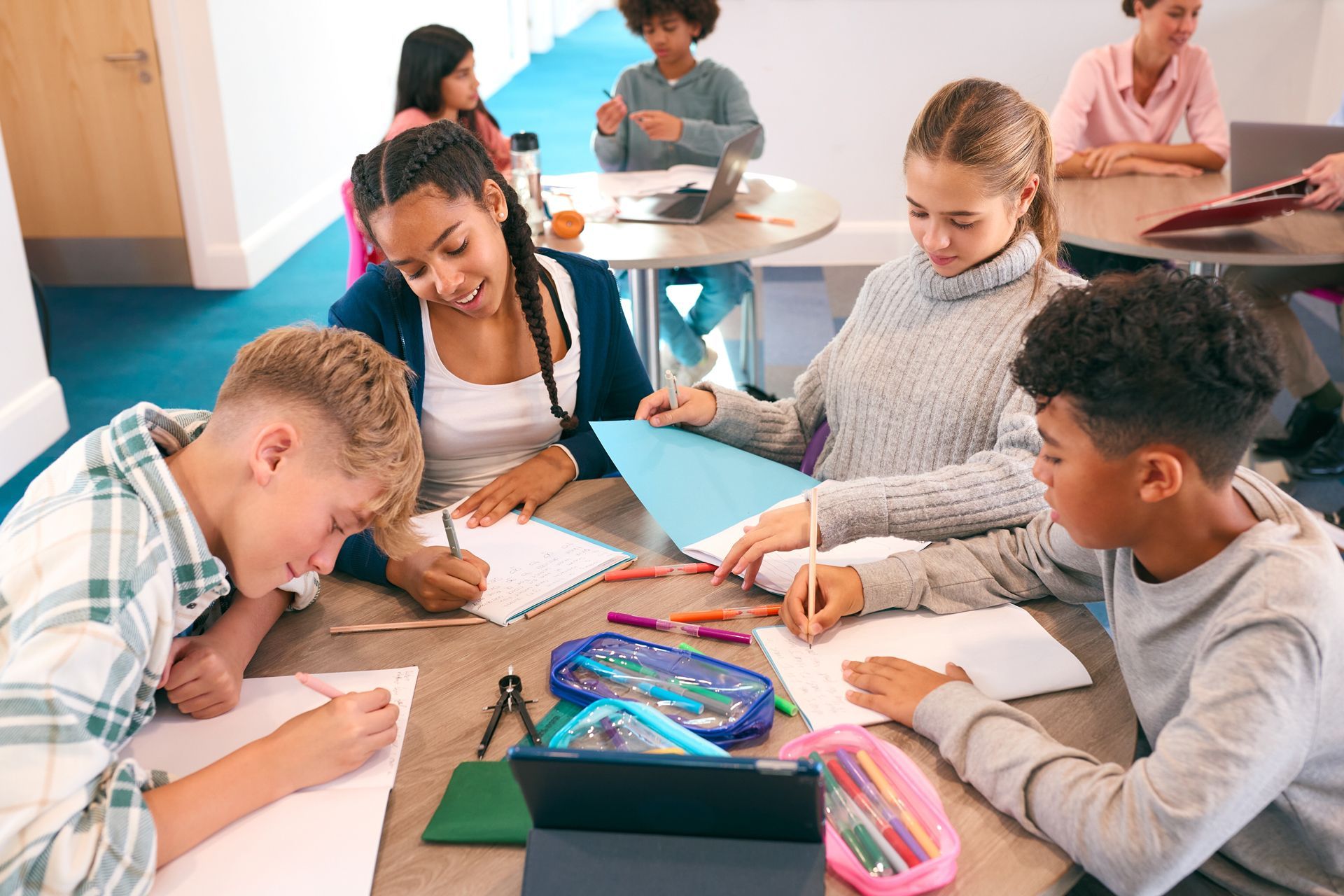 A Group of Young People Are Sitting Around a Table in a Classroom