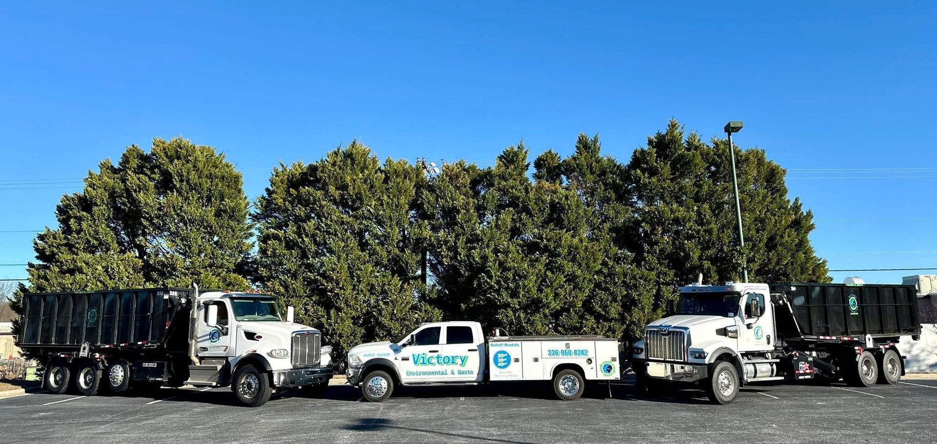 A row of trucks are parked in a parking lot.