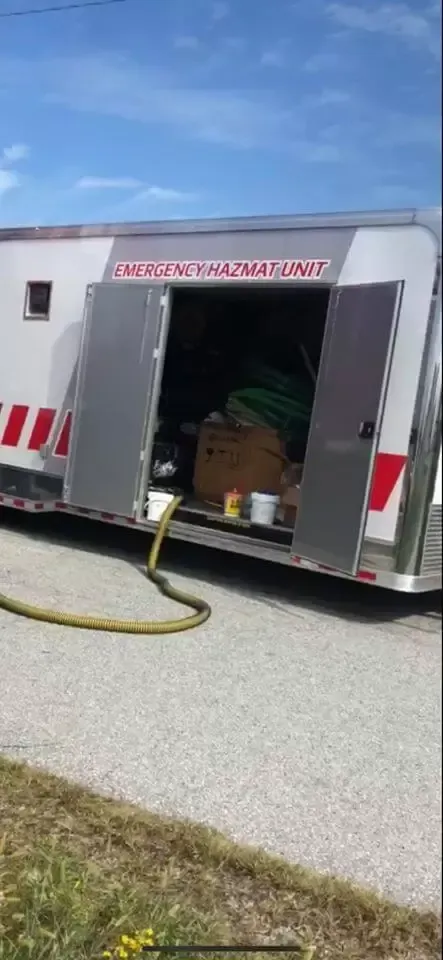 A trailer with its doors open and a hose attached to it.