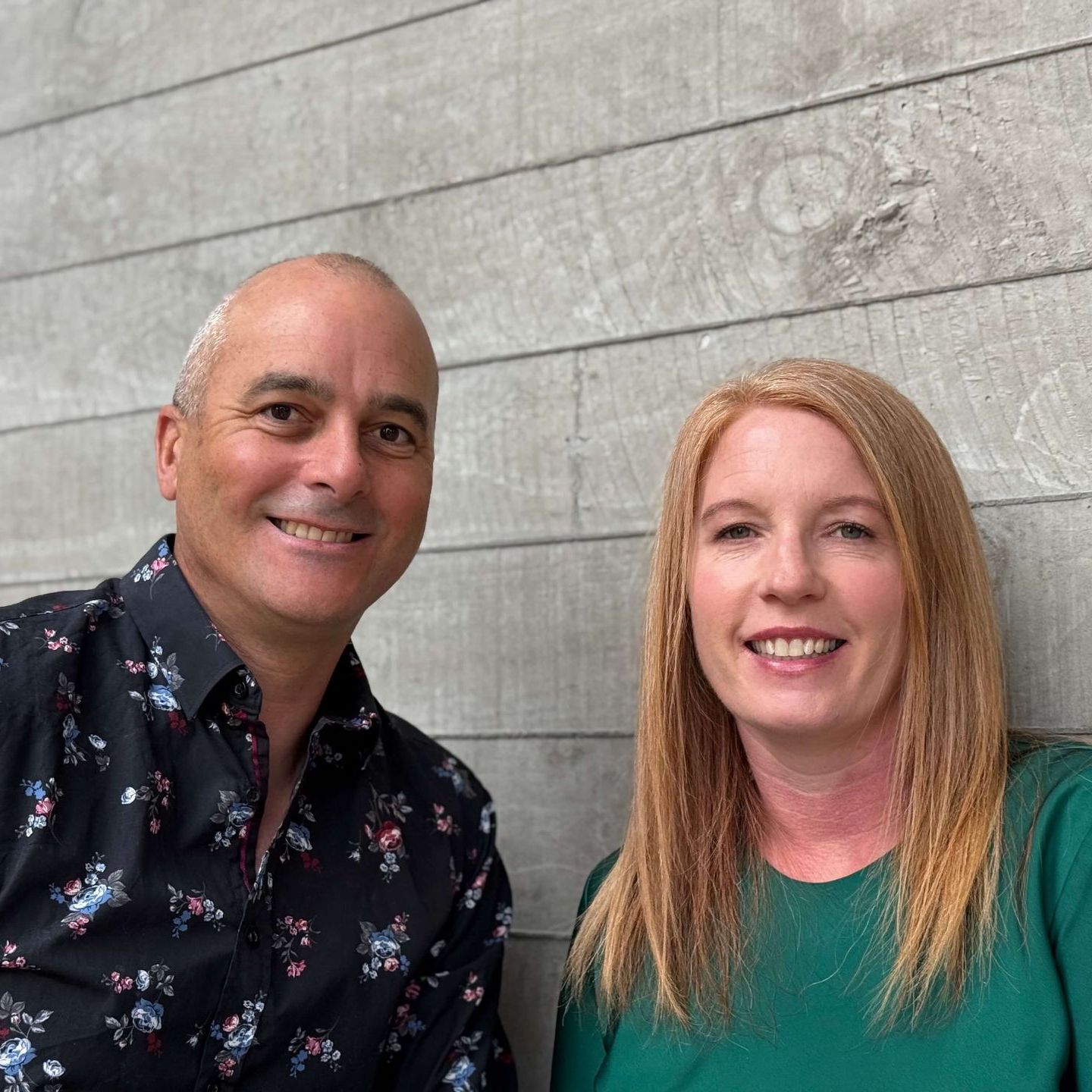 A man and a woman are posing for a picture and smiling for the camera. Statement Homes Christchurch