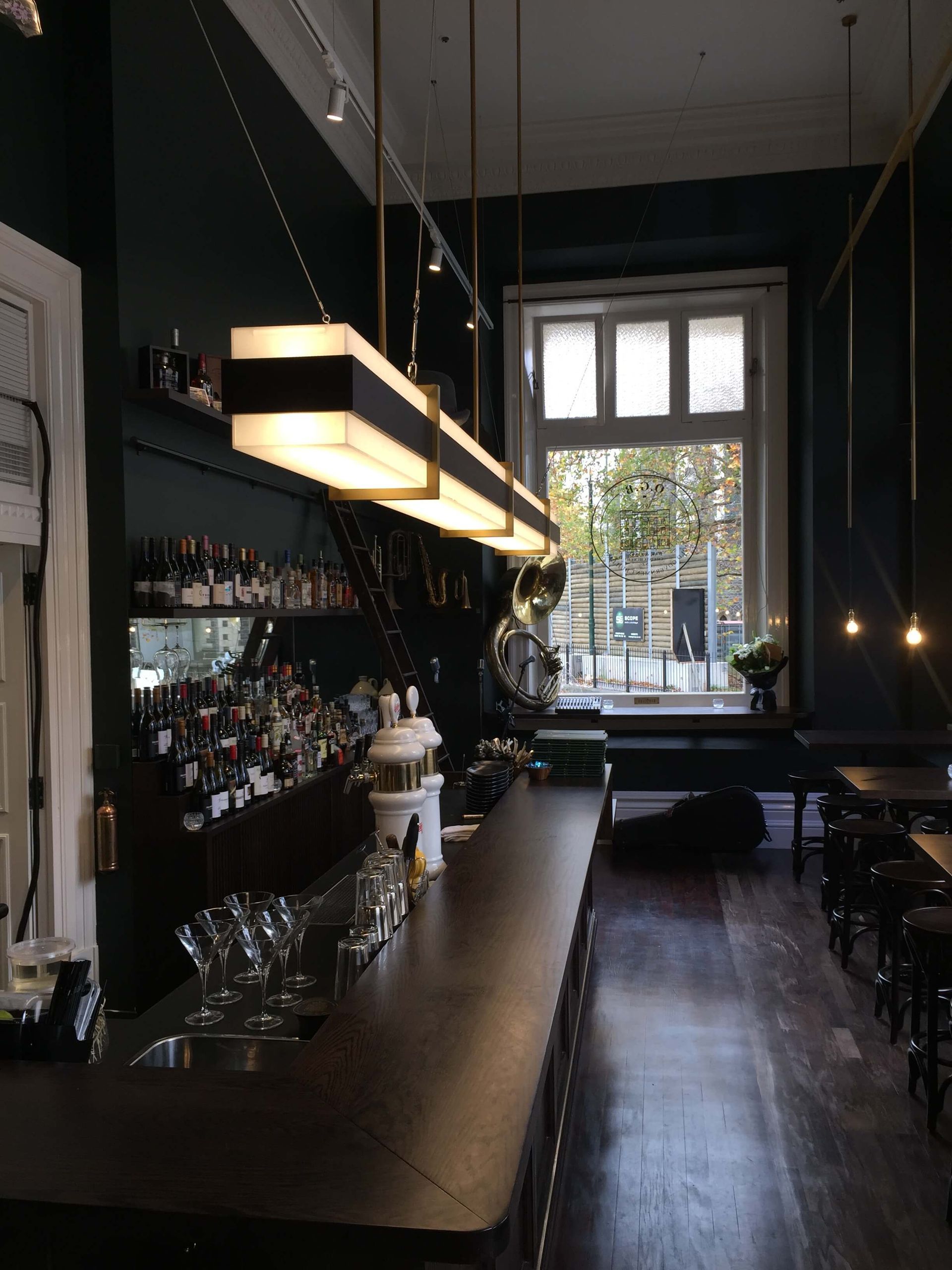 A dark room with a long bar and a window Statement Homes Christchurch