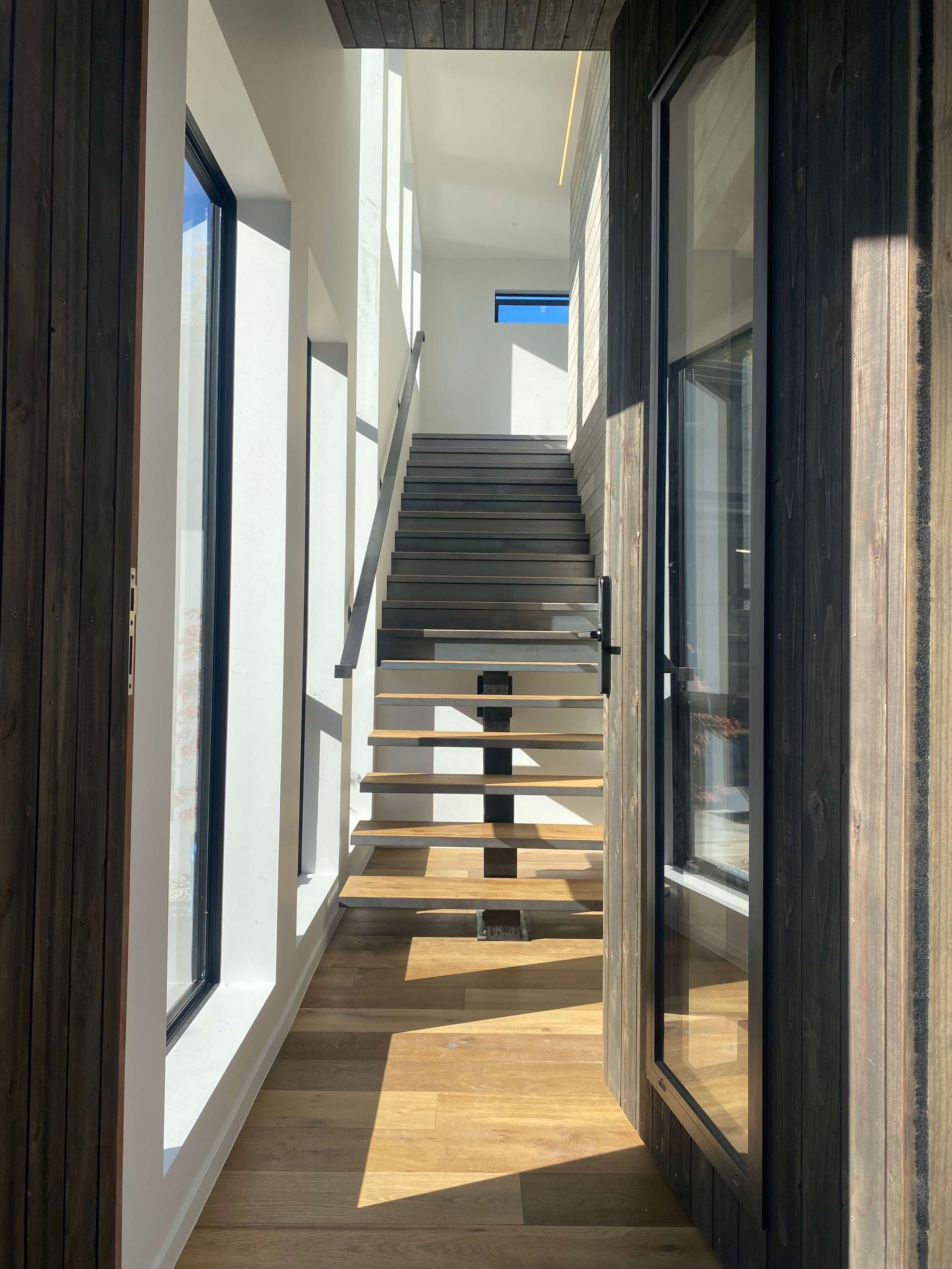 A hallway with stairs leading up to the second floor of a house. Statement Homes Christchurch