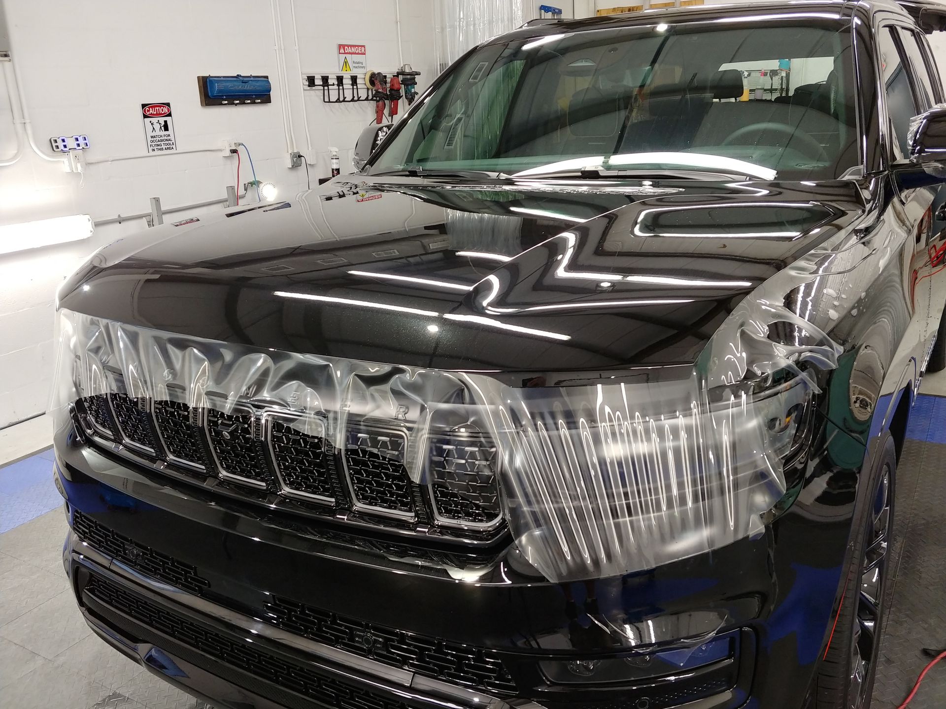 Black SUV with shiny exterior, likely in a detailing shop.