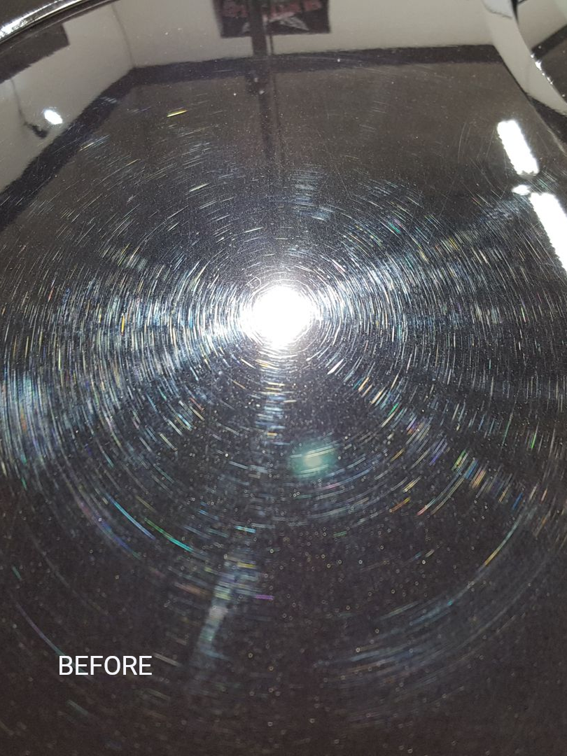 Black car hood with reflective lights, BMW logo, and a dark square area.