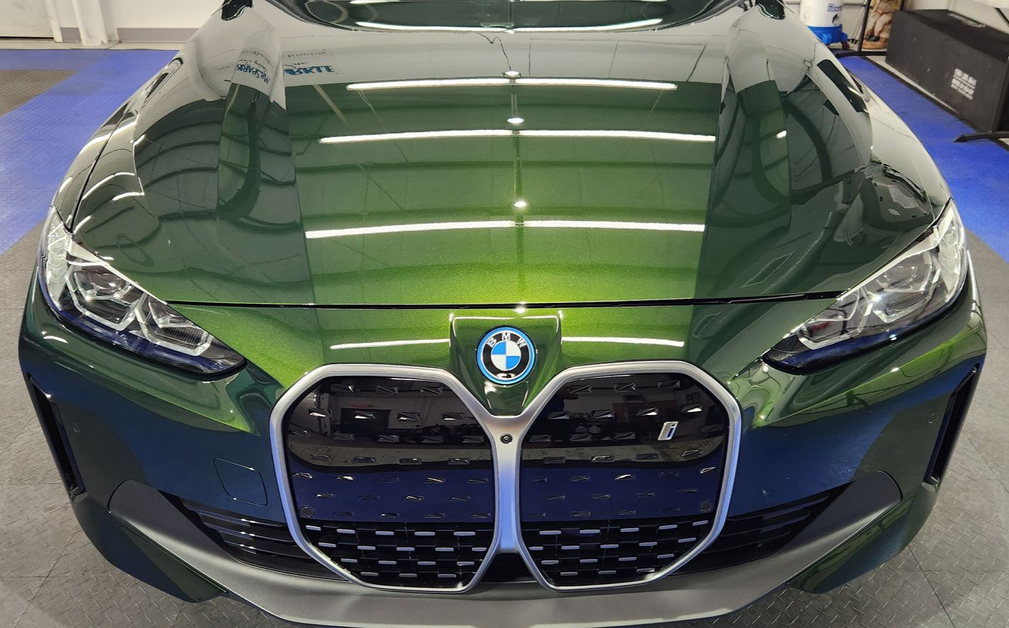 Green BMW SUV, front view, shiny finish, chrome grill, blue and white emblem.