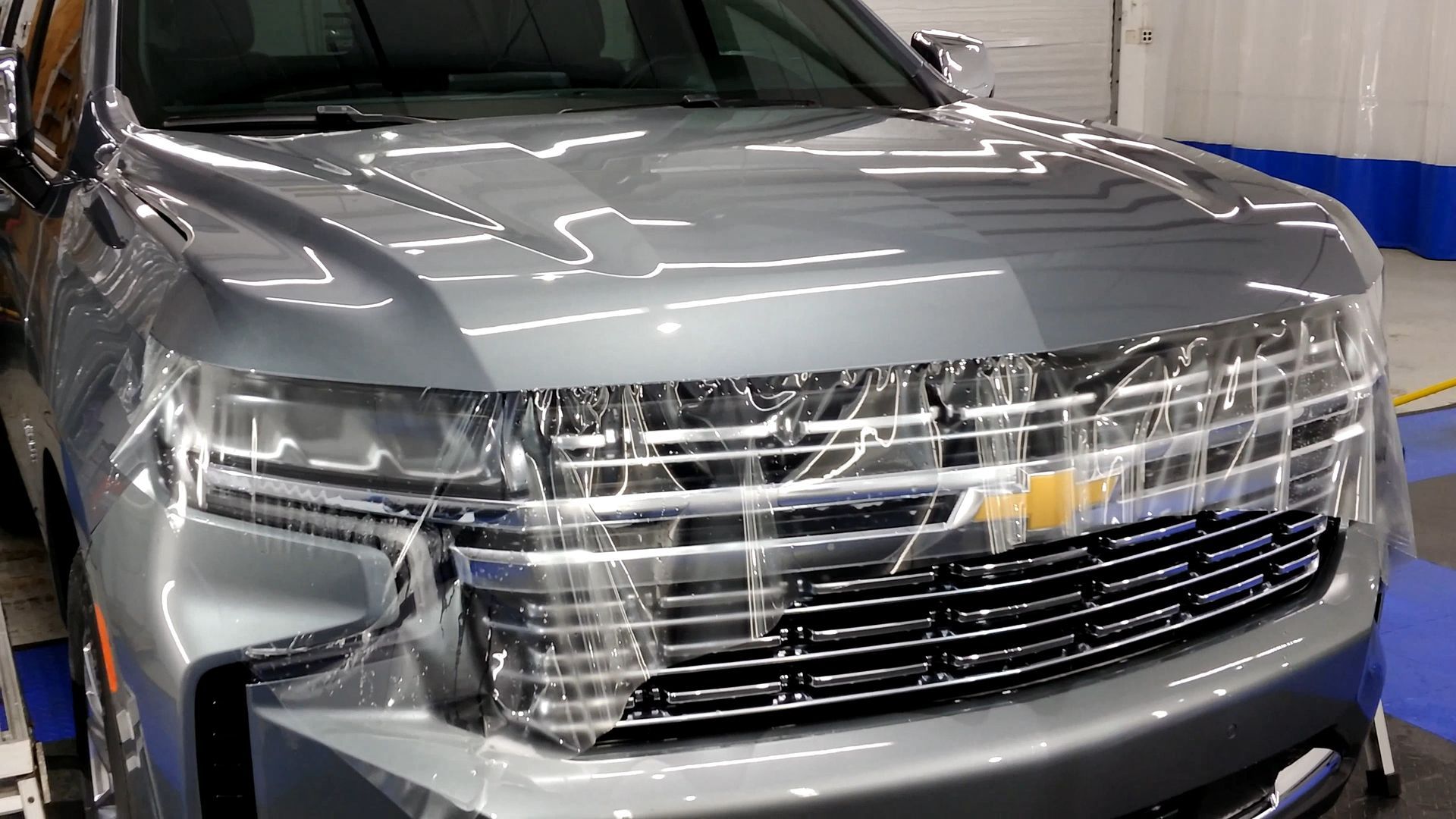 Silver Chevrolet SUV, front view, shiny grill and headlights.