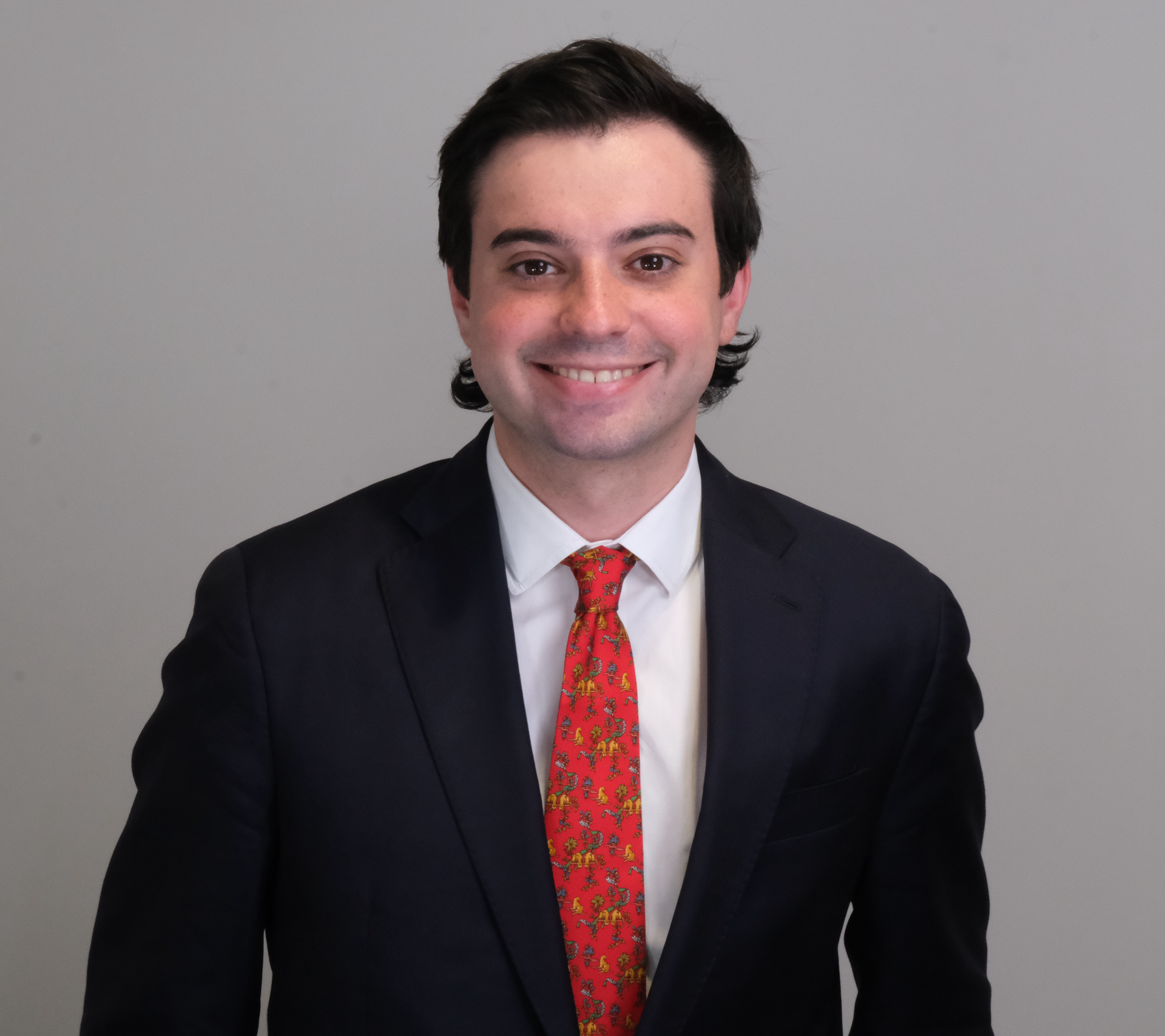 A.B. Steinberg in suit with red patterned tie smiles at the camera.