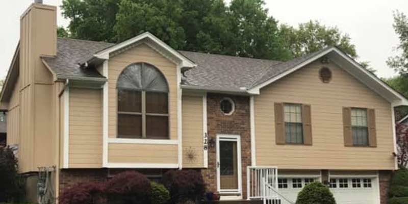 A large house with a gray roof and a large window