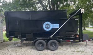 A dumpster trailer is parked in a driveway next to a house.