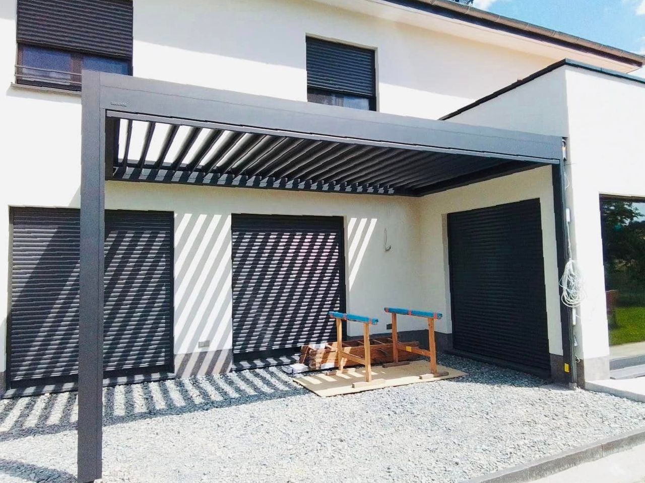 Une maison blanche avec une pergola devant