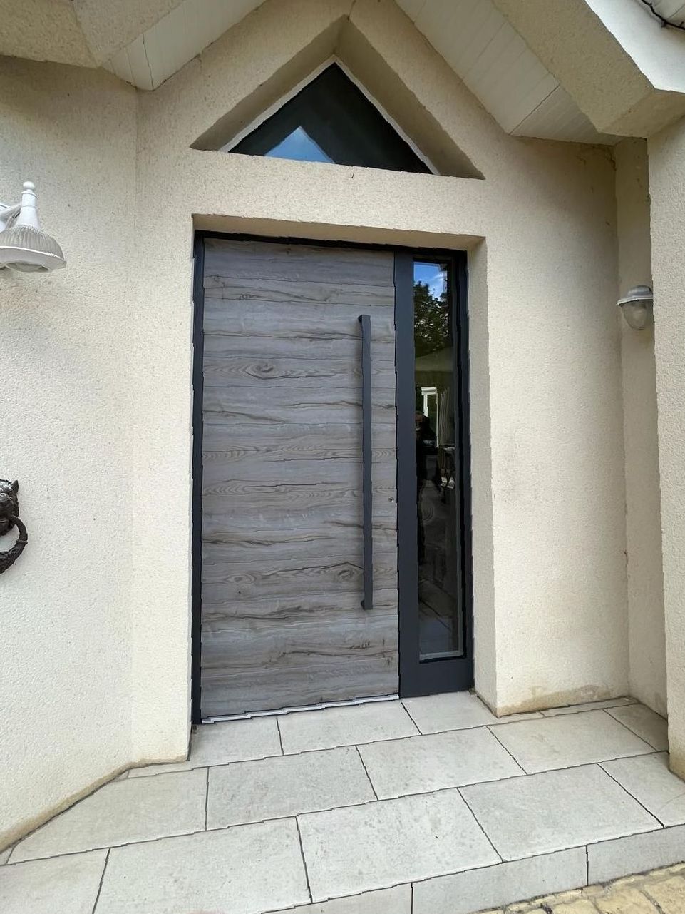 La porte d'entrée d'une maison avec une porte en bois et une porte vitrée