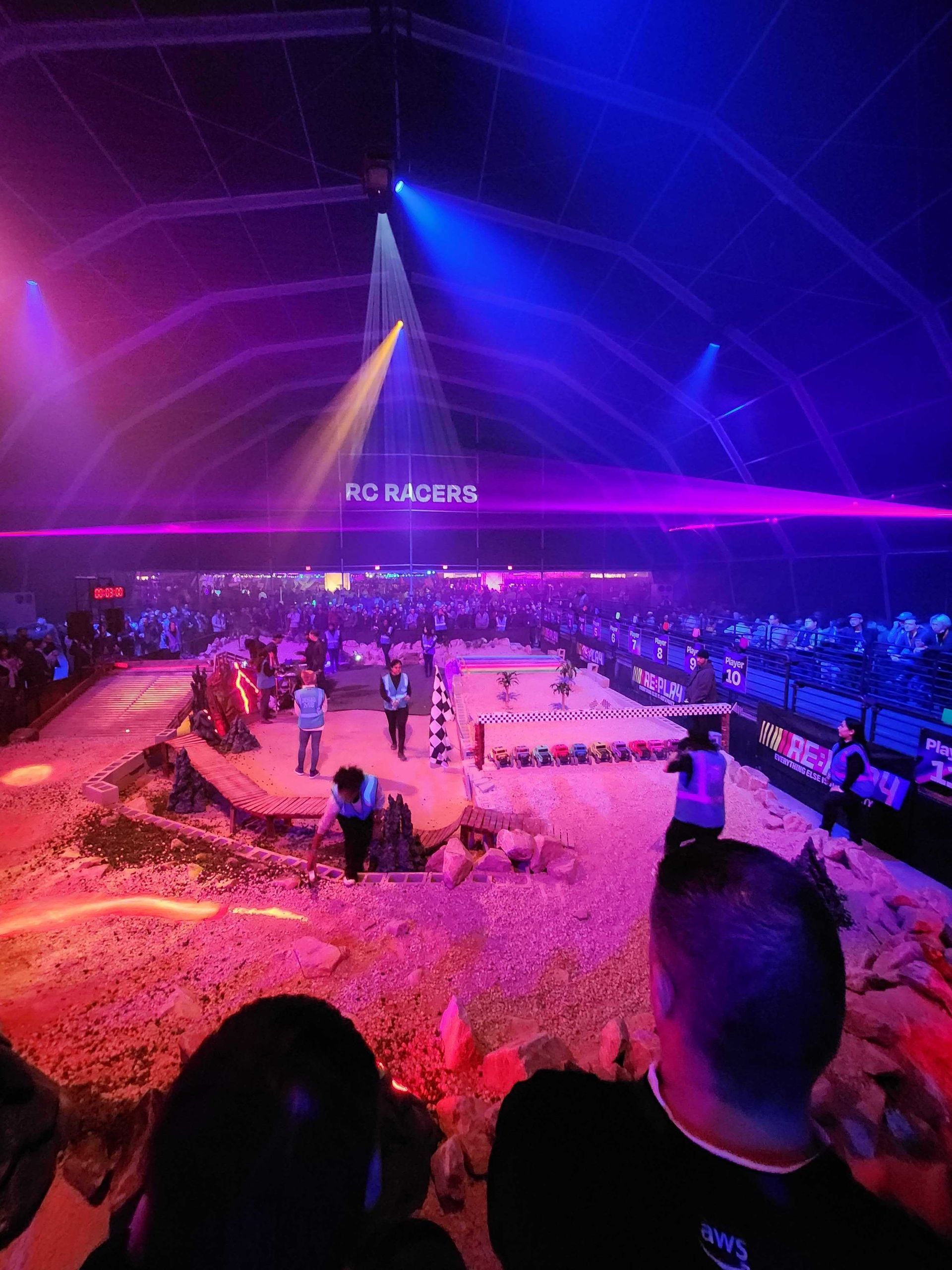 A group of people are watching a show in a stadium with purple lights