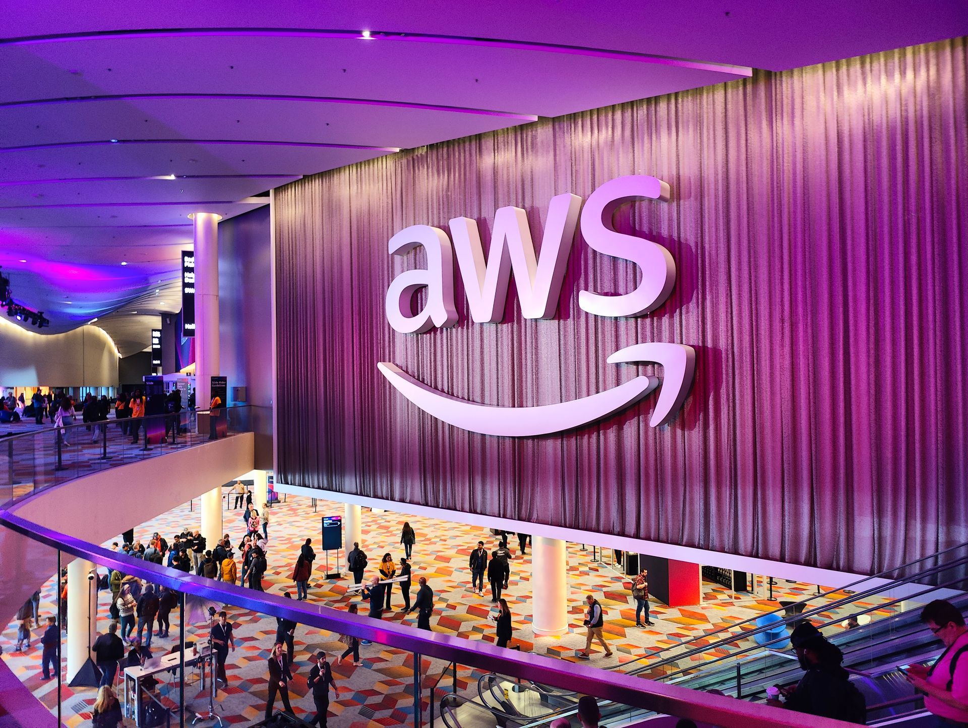 A large aws logo is hanging from the ceiling of a building.