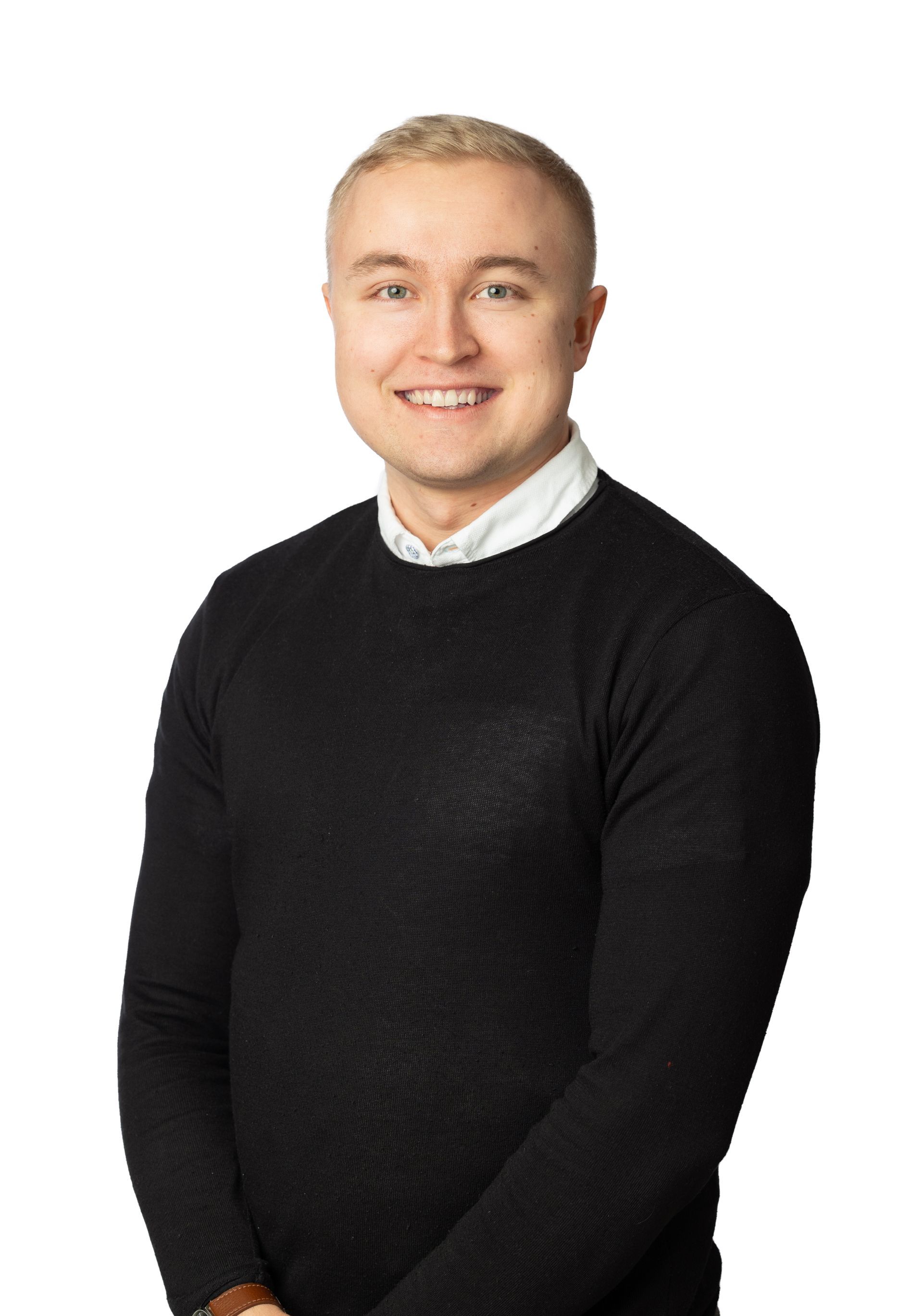 A man in a black sweater and white shirt is smiling for the camera.