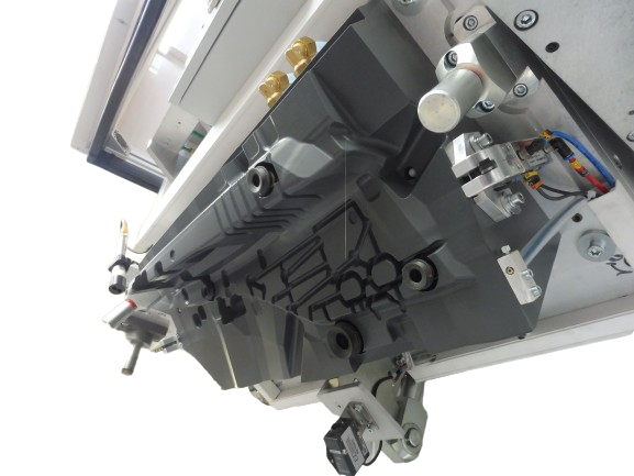 Gros plan des composants de la machine avec boîtier en plastique gris et pièces métalliques, sur fond blanc.