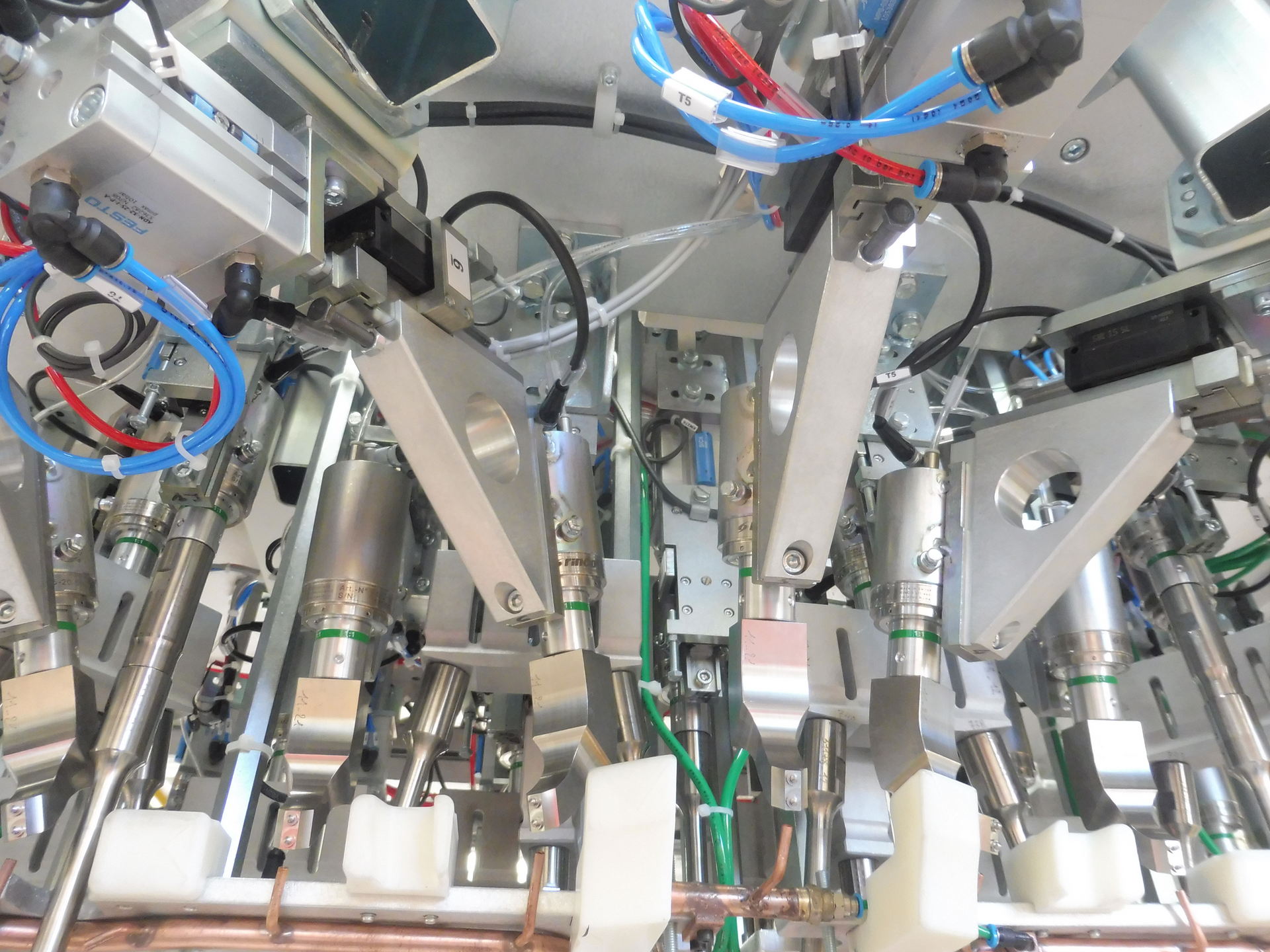 Machines complexes comportant de nombreux bras, tubes et fils métalliques, probablement destinées à l'assemblage ou au traitement industriel.