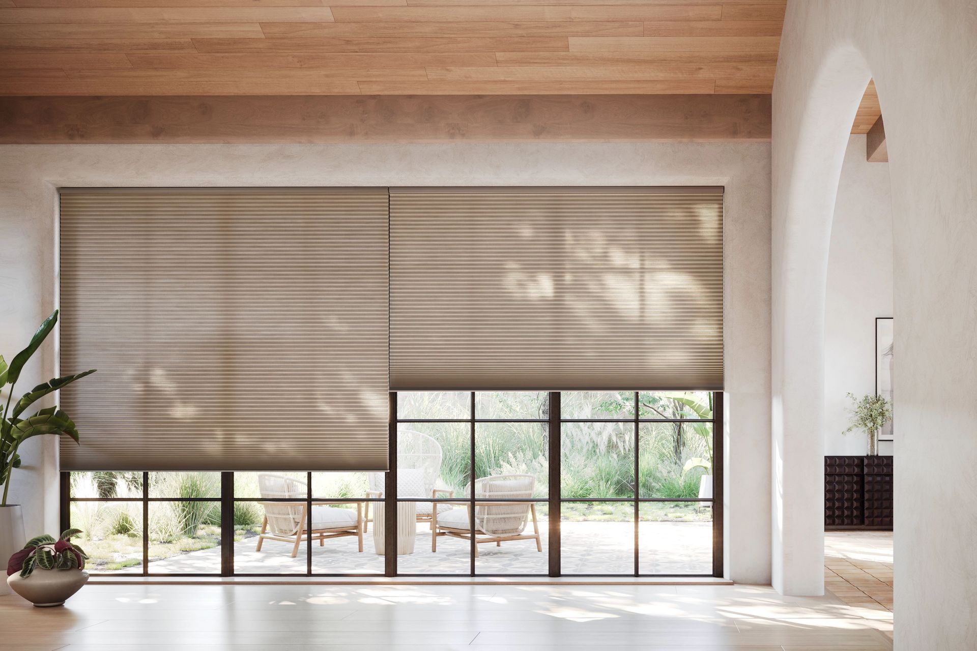 a spacious room with blinds on a large window and a wooden floor.