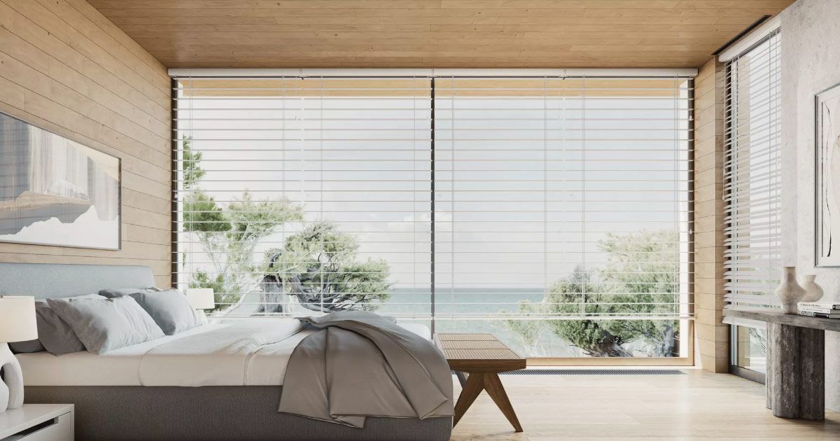 A bedroom with a bed and a large window with a view of the ocean.