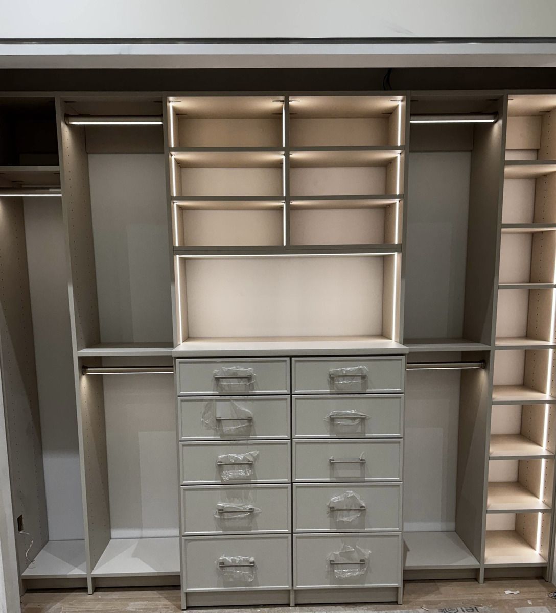 A walk in closet with lots of shelves and drawers