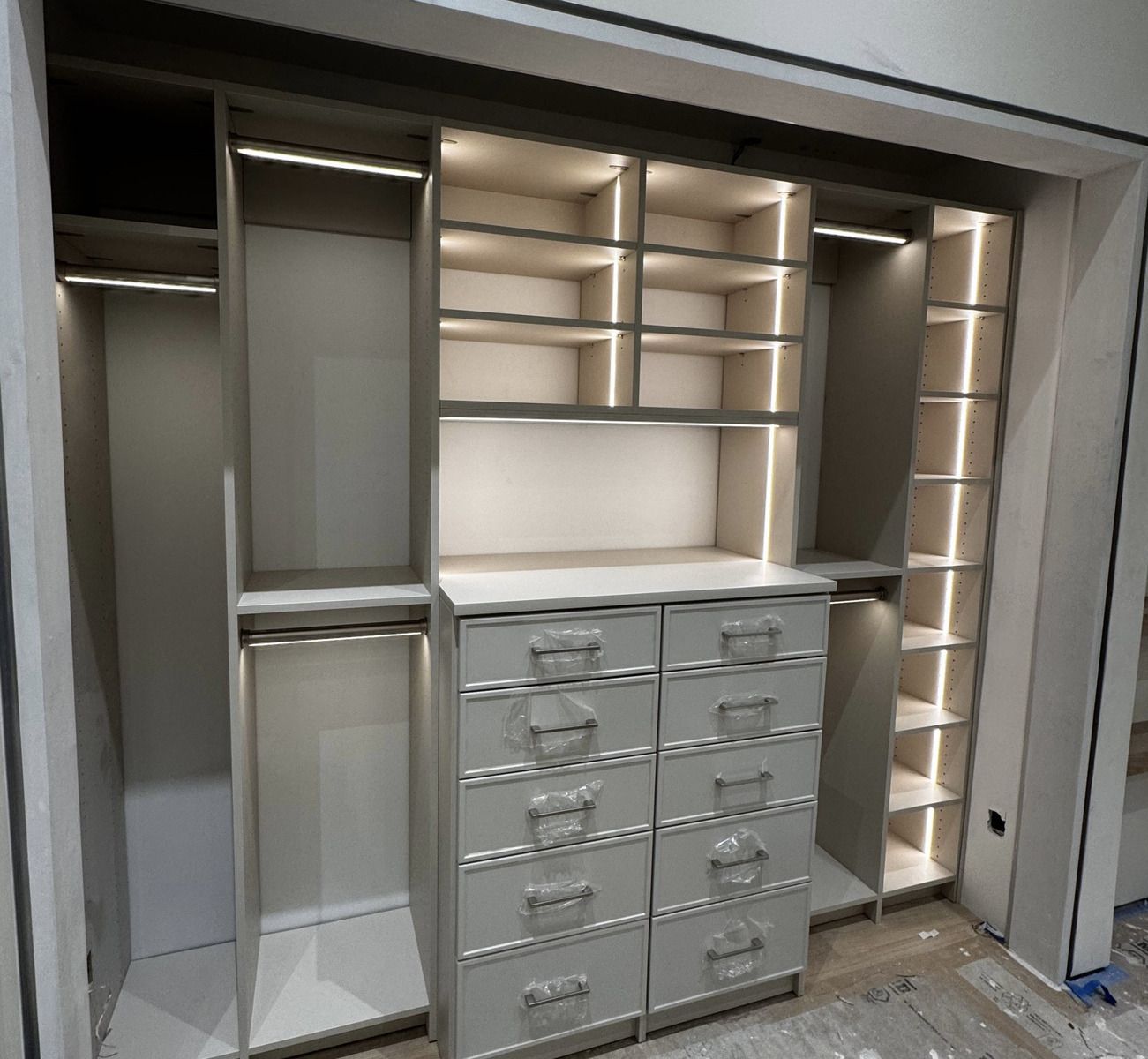 A walk in closet with lots of shelves and drawers