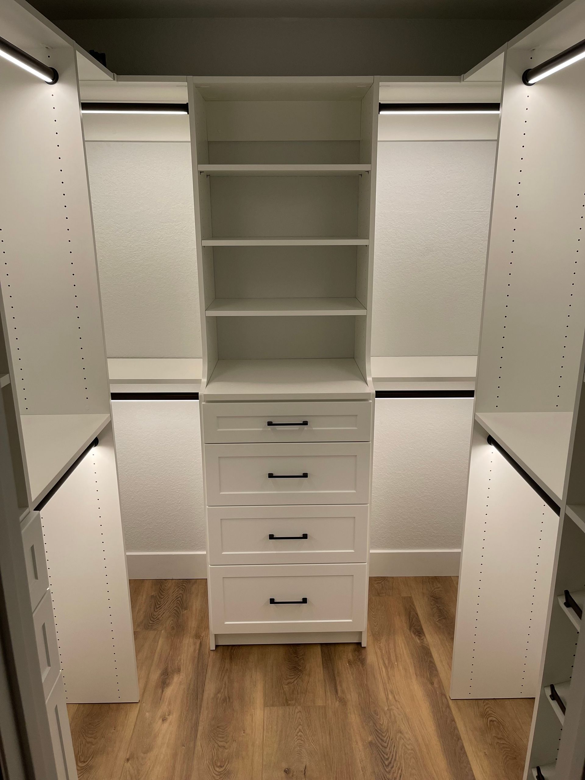 a walk in closet system with lots of shelves and drawers and LED lighting