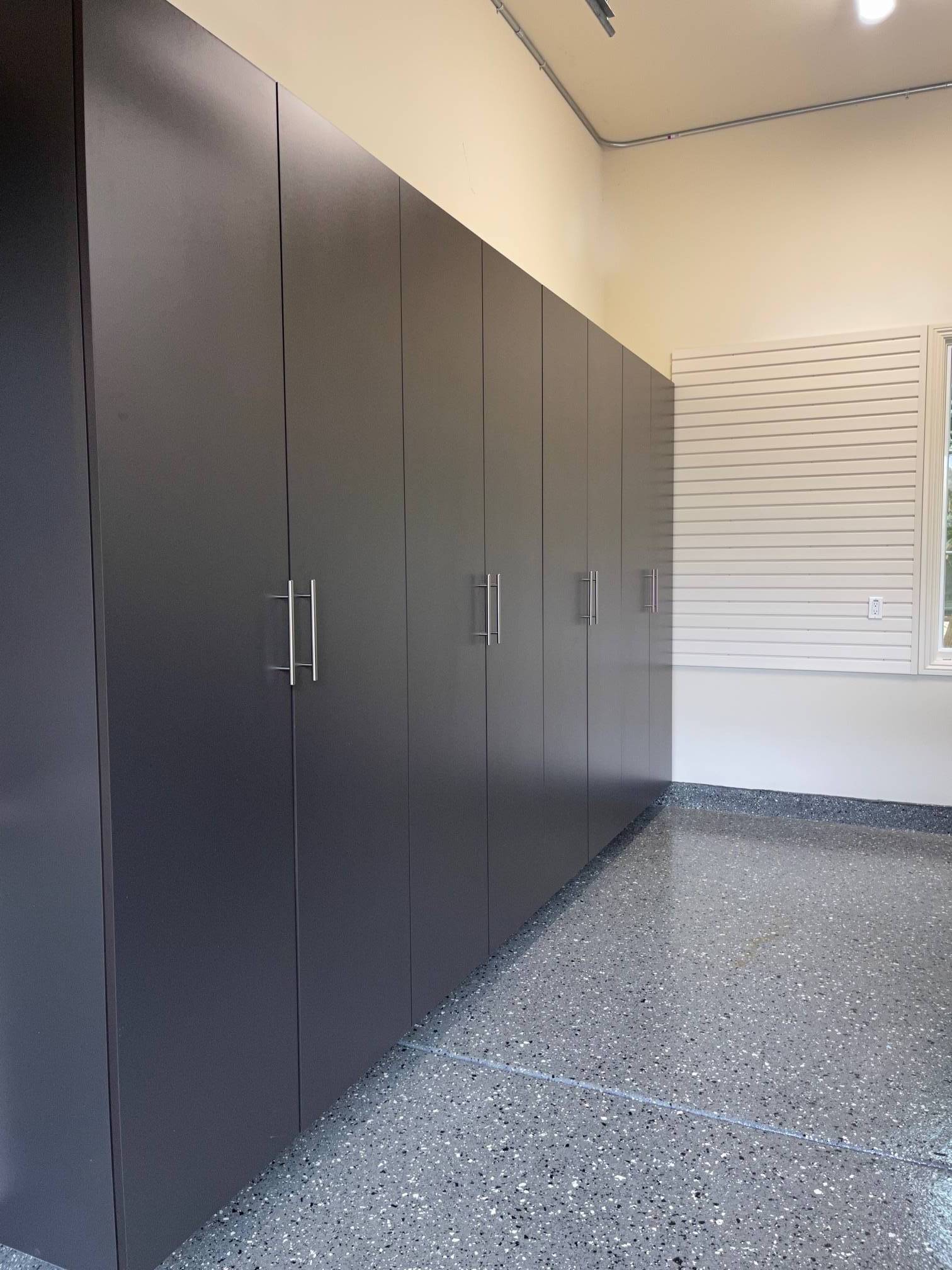 a garage with a lot of slate cabinets and a gray floor .
