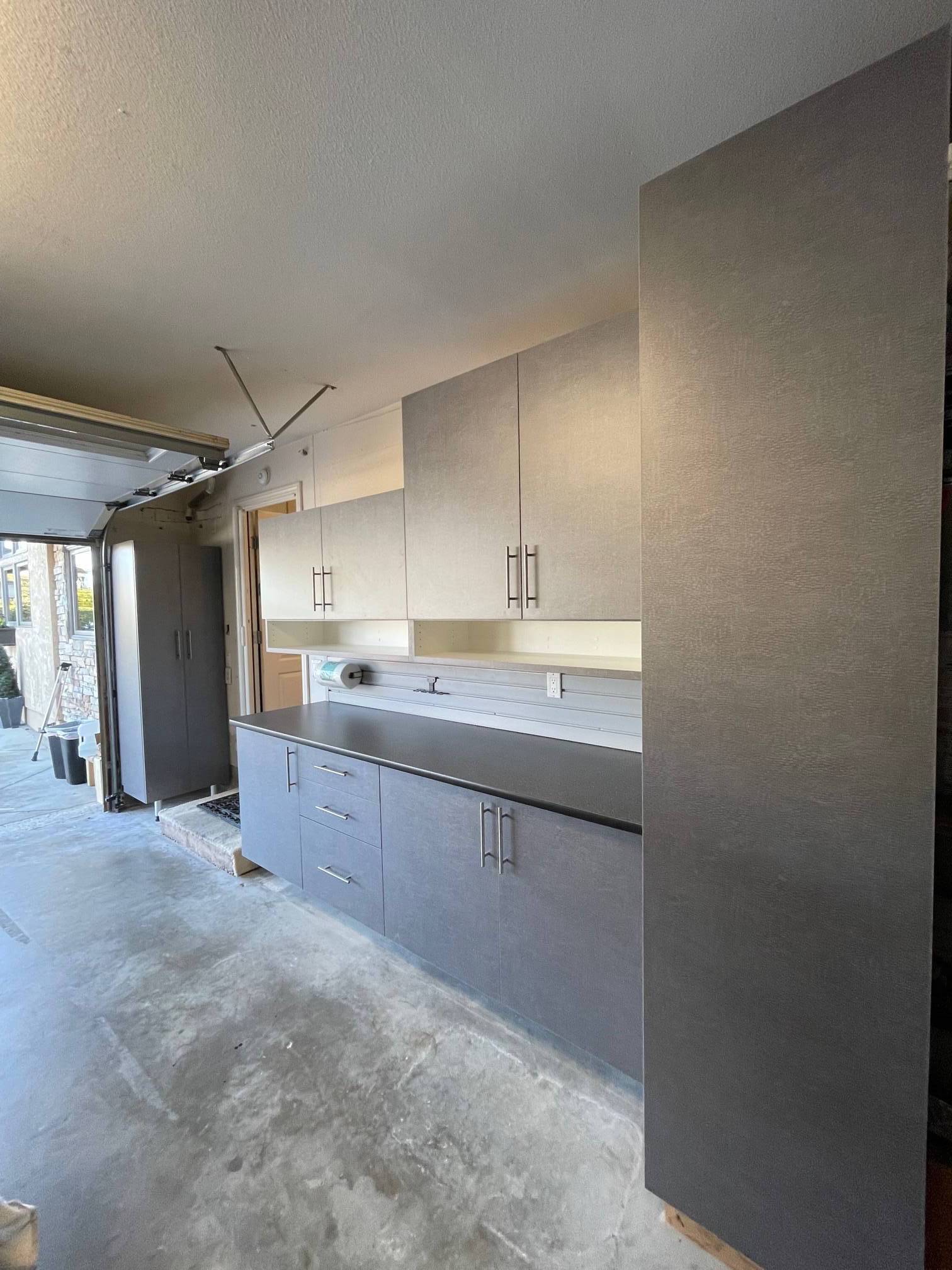a garage cabinet system with a workbench and cabinets .