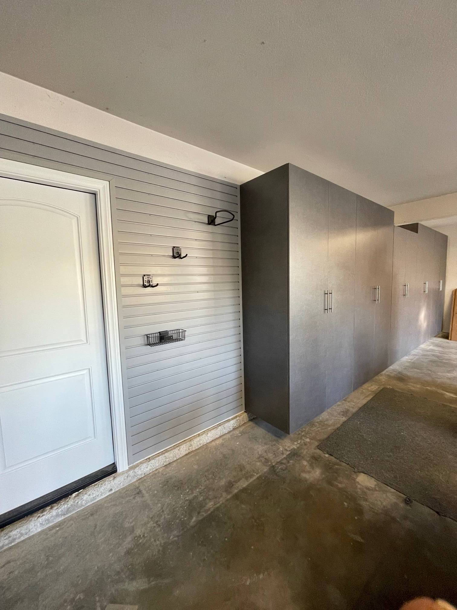 a large garage with lots of storage space and a white door .