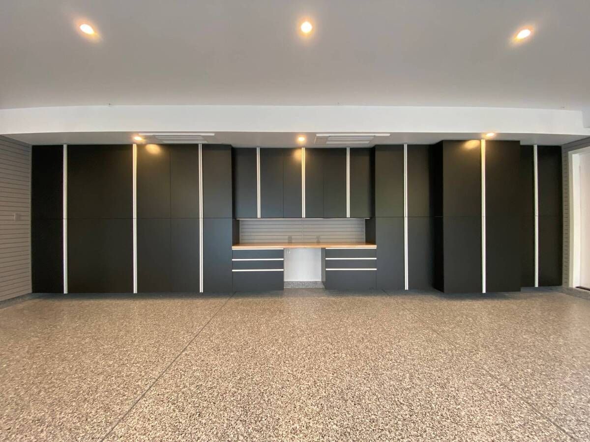 a large empty garage with basalt cabinets and a epoxy floor .